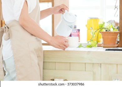 Portrait Of Young Adult Brunette Asian Woman Making Tea Or Green Tea On Kitchen Room