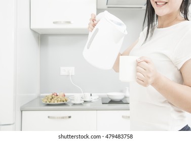 Portrait Of Young Adult Brunette Asian Woman Making Tea Or Green Tea On Kitchen Room Interior Background Empty Copy Space For Inscription Girl With Coffee Cup