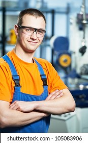 Portrait of young adult experienced industrial worker over industry machinery production line manufacturing workshop