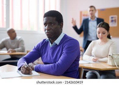 Portrait Of Young Adult Male Studying In Classroom With Colleagues