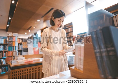 Portrait of young adult southeast asian woman reading book at bookstore shop. University student female leisure on weekend. Relax trend with knowledge. 