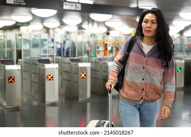 Portrait of young adult woman at subway station hall going to train