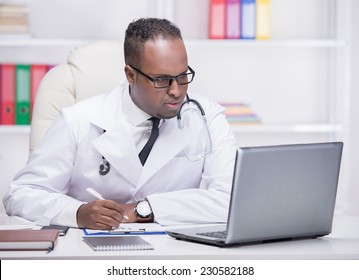 Portrait Of Young African American Doctor At Work, With Laptop.