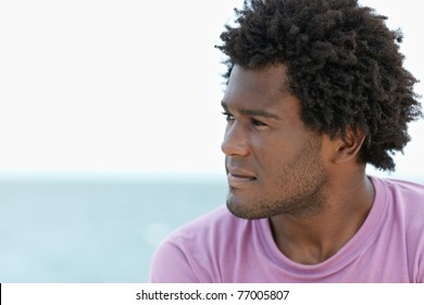 portrait of young african american guy looking away near the sea. Horizontal shape; head and shoulders; copy space