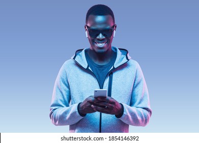 Portrait of young african american man using smartphone to listen music with earphones - Powered by Shutterstock