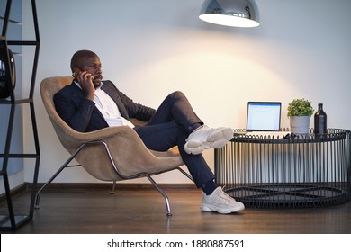 retrato de un joven afroamericano con traje sentado en una silla. enfoque suave