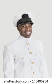 Portrait Of A Young African American US Navy Officer Smiling Over Gray Background