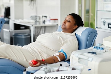 Portrait Of Young African American Woman Giving Blood While Laying In Chair At Plasma Donation Center