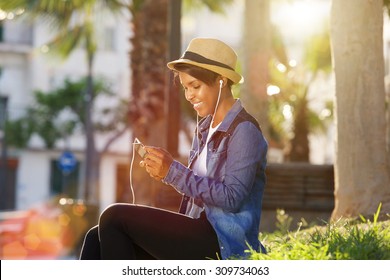 Portrait Of A Young African American Woman Listening To Music On Cell Phone