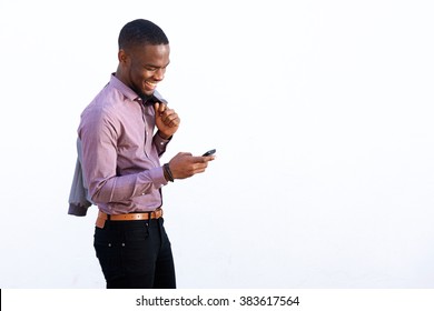 Portrait Of A Young African Guy Reading Text Message On Cell Phone Against White Background