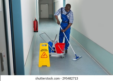Portrait von jungen afrikanischen Männern Janitor Reinigungsboden im Korridor