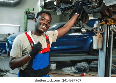 Portrait of young african man car service worker wearing uniform standing in garage - Powered by Shutterstock