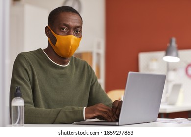 Portrait Of Young African-American Businessman Wearing Mask And Using Laptop While Working In Office Cubicle, Copy Space