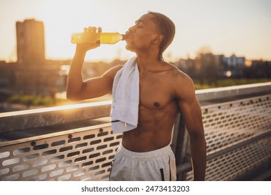 Portrait of young african-american man who is drinking water and relaxing after jogging. - Powered by Shutterstock