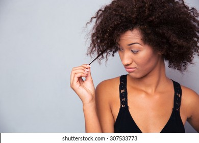 Portrait Of A Young Afro American Woman Touching Her Hair Over Gray Background