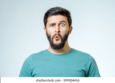 Portrait of young amazed man isolated on gray background - Shutterstock ID 599304416