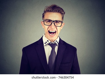 portrait of young angry business man screaming 