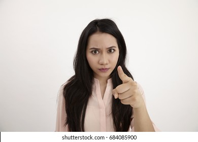 Portrait of a young angry woman pointing finger at camera isolated on a white background - Shutterstock ID 684085900