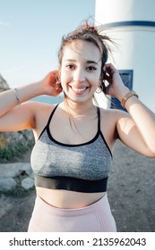 Portrait Of A Young Arab Woman Outdoors On Sport Clothes While Smiling To Camera. Carefree And Freedom Concept. Healthy Lifestyle Doing Exercise Outdoors. Super Smile With Confident Attitude