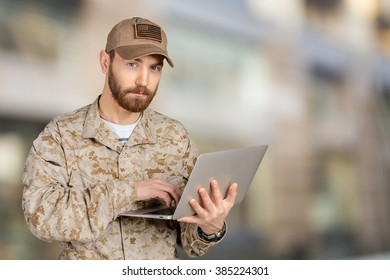 Portrait Of Young Army Soldier With A Laptop