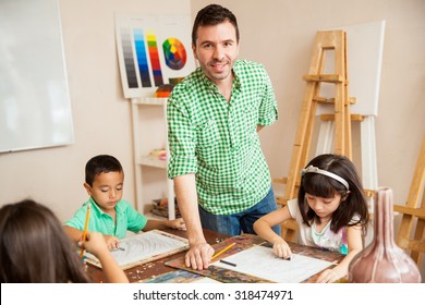 Portrait Of A Young Art Teacher Helping His Students And Smiling In The Classroom