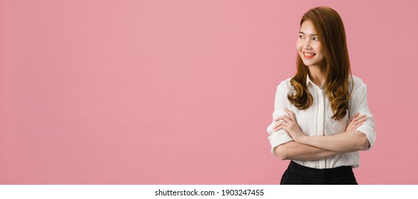 Portrait of young Asia lady with positive expression, arms crossed, smile broadly, dressed in casual clothing and looking at space over pink background. Panoramic banner background with copy space.