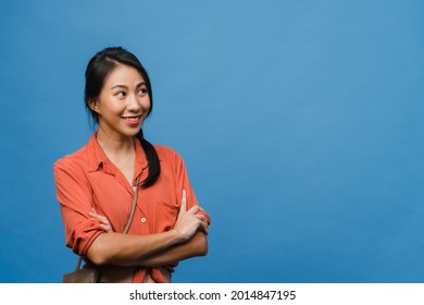 Portrait of young Asia lady with positive expression, arms crossed, smile broadly, dressed in casual cloth over blue background. Happy adorable glad woman rejoices success. Facial expression concept.