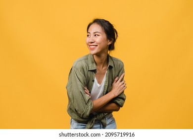 Portrait of young Asia lady with positive expression, arm crossed, smile broadly, dressed in casual cloth over yellow background. Happy adorable glad woman rejoices success. Facial expression concept. - Shutterstock ID 2095719916