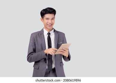 Portrait Young Asian Business Man In Suit Standing Using Tablet Computer To Internet Isolated On White Background, Businessman Confident Touch Screen Digital Pad With Success, Communication Concept.