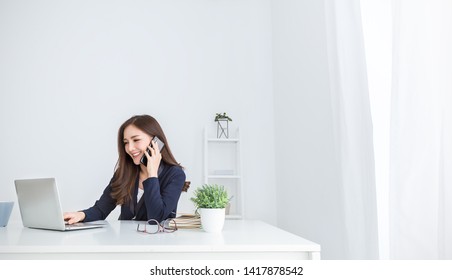 Portrait Young Asian Business Woman Talk On Smartphone Write Notebook Laptop In Home Office. Beautiful Asian Girl At Desk Computer Take Home Order. Startup Business Asia Woman Online Sme Telemarketing