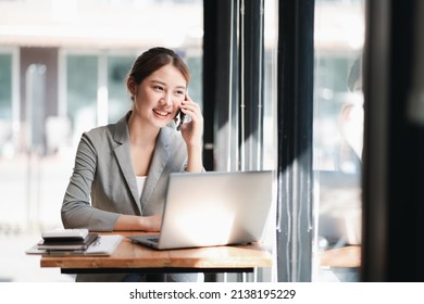 Portrait Of Young Asian Business Woman Talk On Smartphone Write Notebook Laptop In Home Office. Beautiful Girl At Desk Computer Take Home Order. Startup Business Asia Woman Online Sme Telemarketing.