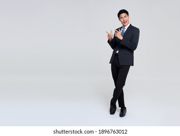 portrait of young Asian businessman hand pointing up to copy space isolated on studio white background.