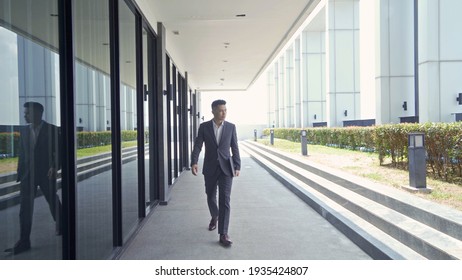 Portrait Of Young Asian Businessman Person With Laptop Computer Notebook Walking From Office Building. People Lifestyle.