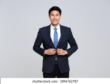 portrait of young Asian businessman smiling confidently while standing isolated on studio white background.