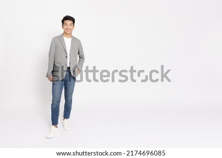 Portrait of young Asian businessman standing and holding laptop computer isolated on white background, Full body composition
