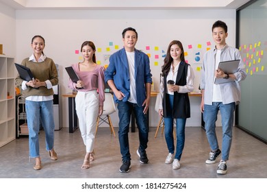 Portrait Of Young Asian Businesspeople Standing Indoors In Office, Looking At Camera.Successful And Confident Business Startup Diversity Team,Corporate Of Modern Colleague