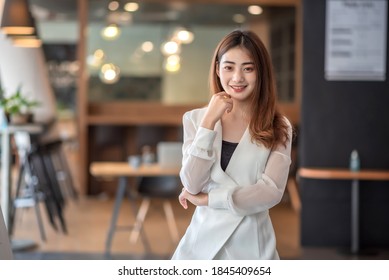 Portrait of young asian businesswoman standing at office. Look at camera. - Powered by Shutterstock