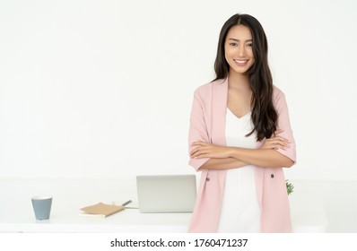 Portrait Of Young Asian Casual Woman Smiling Working Small Business Online Standing With Arms Crossed And Looking At Camera At Her Home Office. Freelance Startup Small Business Owner,Online Selling.