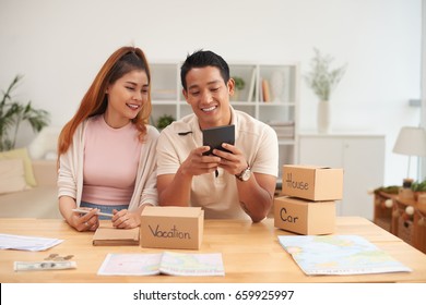 Portrait Of Young Asian Couple Planning Family Budget Saving  For House, Car And Vacation