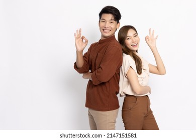 Portrait of young Asian couple showing ok sign isolated on white background, Two people concept