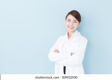 Portrait Of Young Asian Doctor Isolated On Blue Background