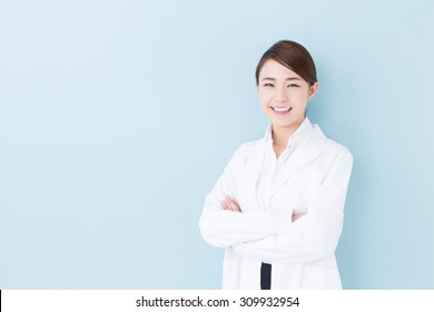 Portrait Of Young Asian Doctor Isolated On Blue Background