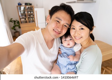 Portrait Of Young Asian Family Talking Selfie Photo In Dining Room