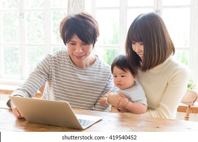 Portrait Of Young Asian Family Using Laptop Computer