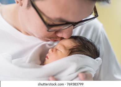 Portrait Of Young Asian Father With His Newborn Baby, Copy Space With Bed In The Hospital Background. Top View Father's Day Concept