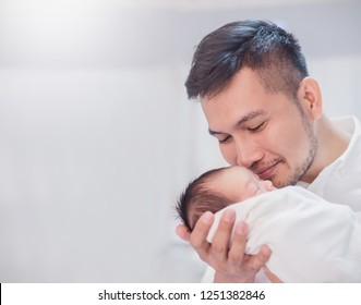 Portrait Of Young Asian Father Holding His Newborn Baby With Copy Space In Hospital Bed. Healthcare And Medical Nursery Love Lifestyle Together Single Dad Father’s Day Holiday Concept