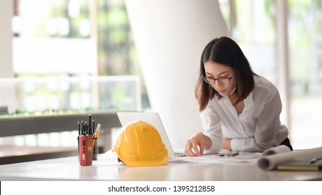 Portrait Of Young Asian Female Architect Working On Project In Site Office