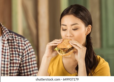 Portrait Of Young Asian Girl Eating Tasty Burger