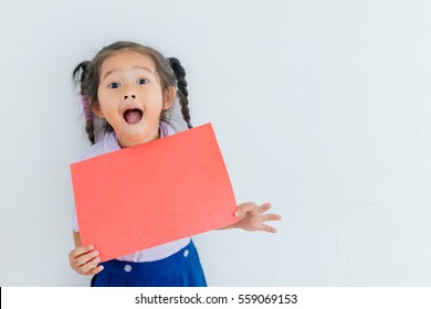 Portrait Of A Young Asian Little Girl Holding A Blank Sign Red Paper On White Background