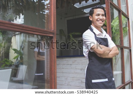 portrait of young asian male cafe worker smiling to camera